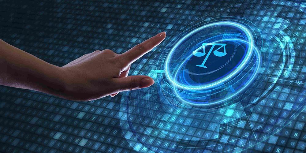 a hand with a pointed index finger tapping on a neon graphic of the scales of law. This is overlaid in blue on top of hundreds of small squares with letters lit up on them.